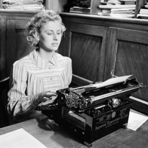 Iris Joyce at work on her typewriter in an office prior to joining the Women's Land Army in 1942